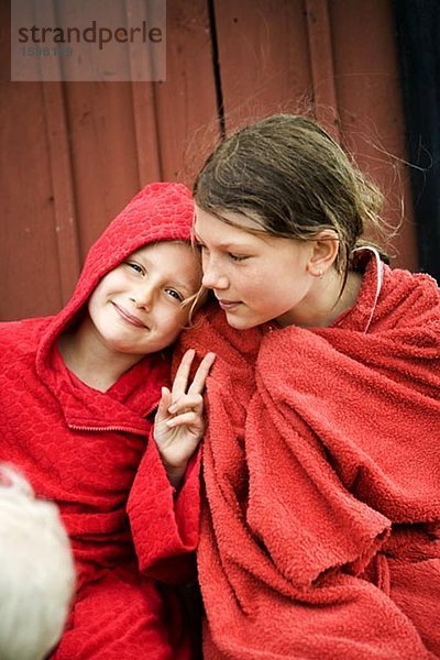 Zwei skandinavische Mädchen sitzen mit ihren Handtüchern umwickelt selbst Oland Schweden.