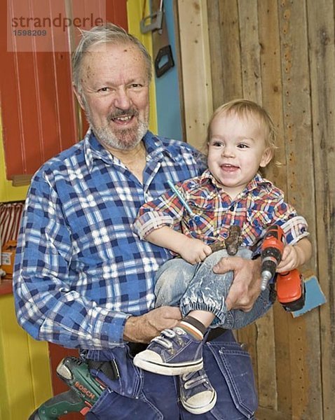 Ein älterer Mann tun Tischlerei mit seinem Enkel Schweden.
