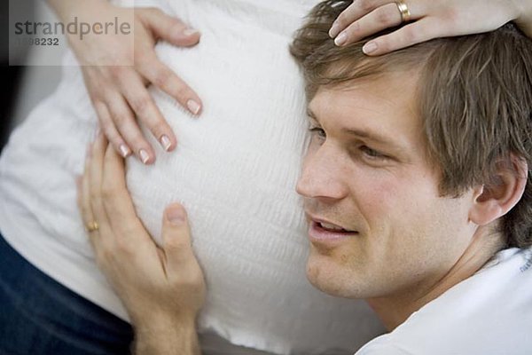 Ein Mann eine schwangere Frau Magen Schweden anhören.