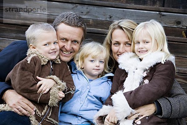 Eine lächelnd Familie mit drei Kindern Schweden.