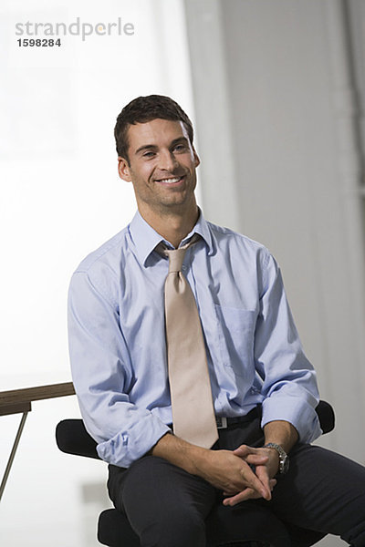 Portrait von einem lächelnd mann in einem Büro.