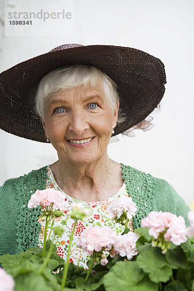 Alte skandinavische Frau mit Pelargonium Schweden.