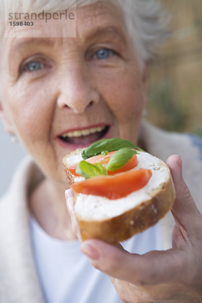 Frau haben einen Sandwich mit Tomaten und Basilikum Schweden.