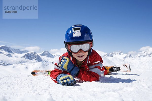 Ein Junge im Ski-Outfit auf Schnee.