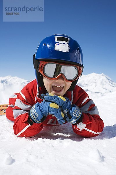 Ein Junge im Ski-Outfit auf Schnee.