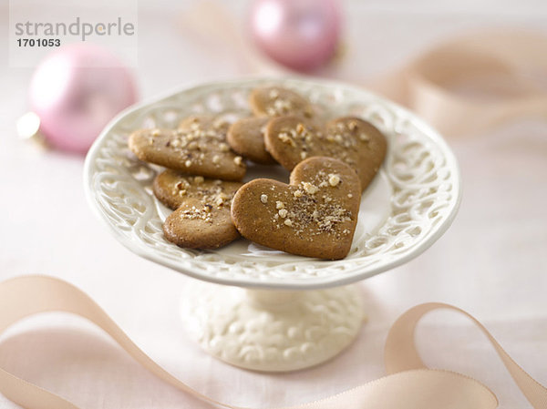 Herzförmige Kekse auf weißem Kuchenständer