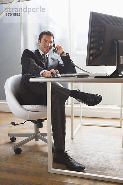 Geschäftsmann am Schreibtisch sitzend