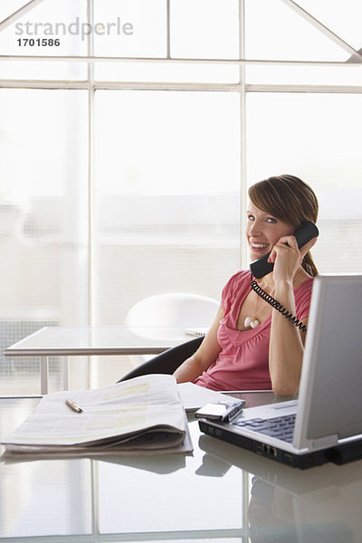 Frau am Schreibtisch mit Telefon