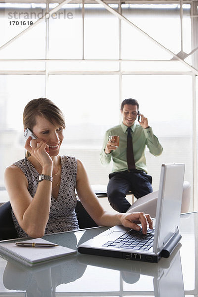 Teamwork in business  woman using laptop while phoning