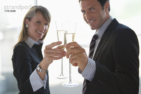 Geschäftsfrau und Geschäftsmann toasten mit Sekt