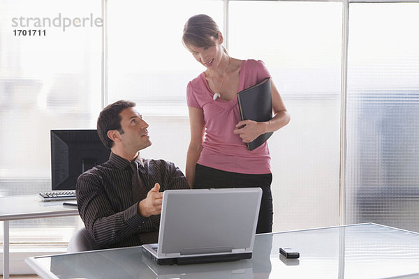 Geschäftsfrau und -mann bei der Arbeit am Laptop  Teamarbeit