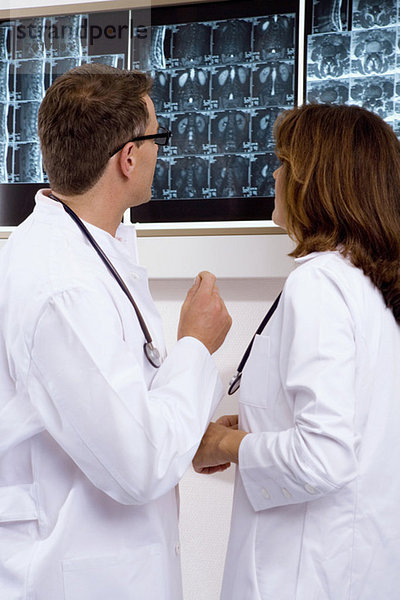 Arzt und Ärztin bei der Untersuchung eines Röntgenberichtes