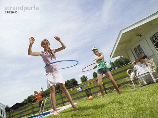 Family in garden  playing with hula-hoops