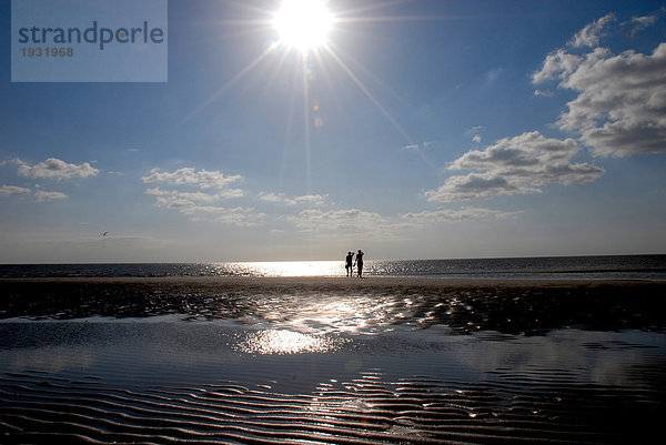 Silhouette von zwei Menschen am Strand