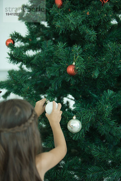 Mädchen schmücken Weihnachtsbaum