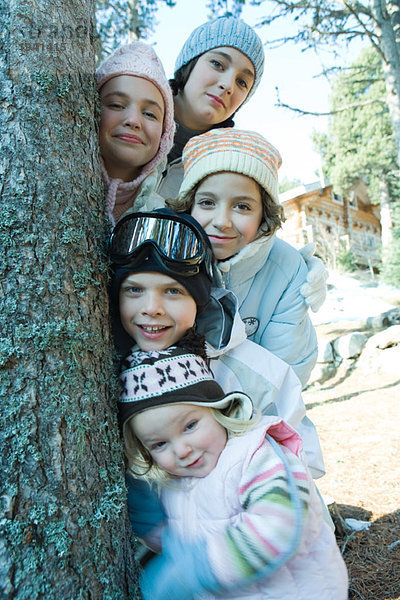 Gruppe von Teenagern und Kindern in Winterkleidung  posierend neben Baum  Portrait