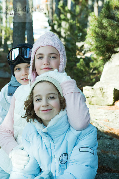 Teenagermädchen mit Jungen und Mädchen in Wintermänteln und Hüten  Portrait