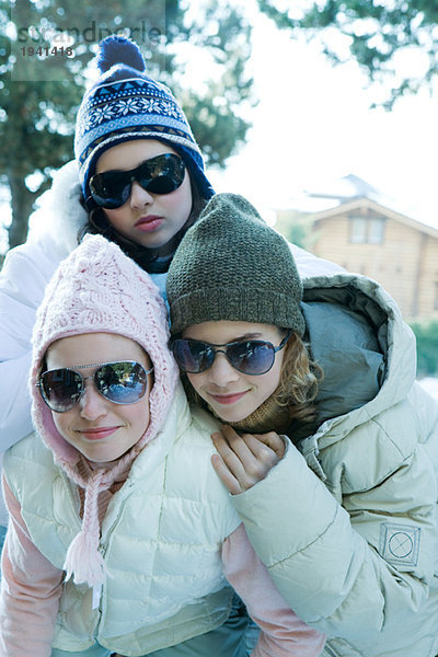 Drei junge Mädchen in Winterkleidung und Sonnenbrille  Portrait