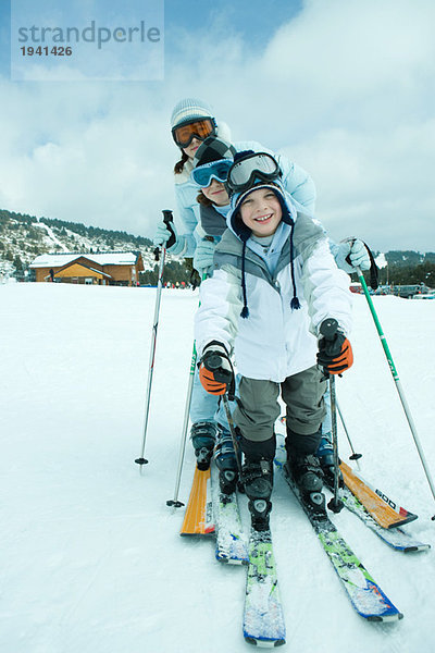 Junge Skifahrer auf Schnee  lächelnd vor der Kamera  volle Länge  Portrait