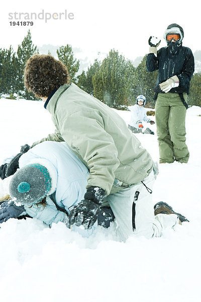 Junge Freunde bei einer Schneeballschlacht im Schnee