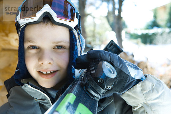 Junge hält Skier auf der Schulter  Portrait