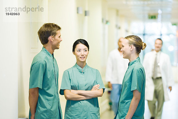 Drei Mediziner im Krankenhausflur im Gespräch