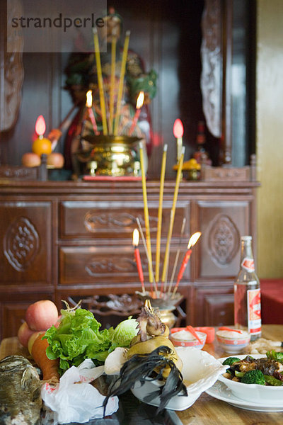 Essen  Weihrauch und Kerzen auf dem Tisch als religiöse Opfergabe