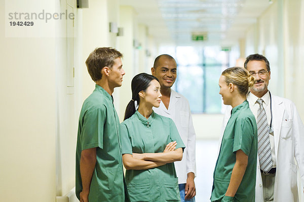 Gruppe von medizinischem Personal im Flur stehend  plaudernd  zwei mit Blick auf die Kamera