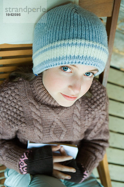 Teenagermädchen lächelnd vor der Kamera  in Winterkleidung gekleidet  hohe Blickwinkel