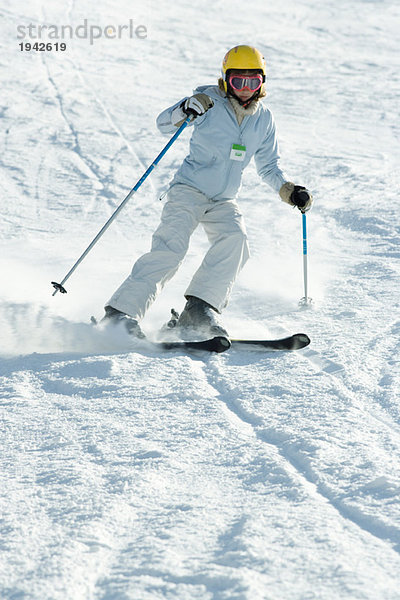 Teenagermädchen beim Skifahren auf der Piste  volle Länge