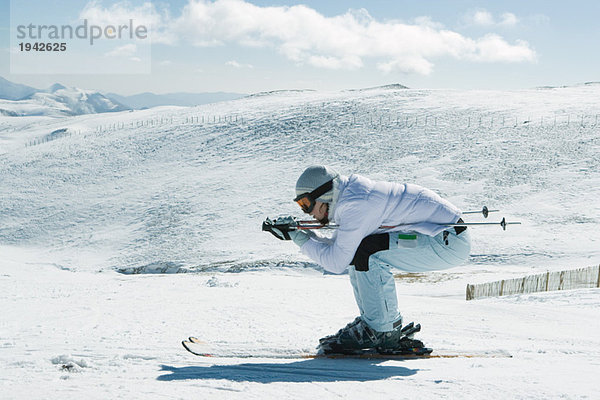 Junge Skifahrerin kauernd  Seitenansicht  Ganzkörperporträt