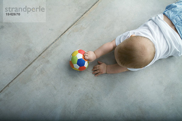 Baby krabbelt auf dem Boden  Halteball  Ansicht von oben