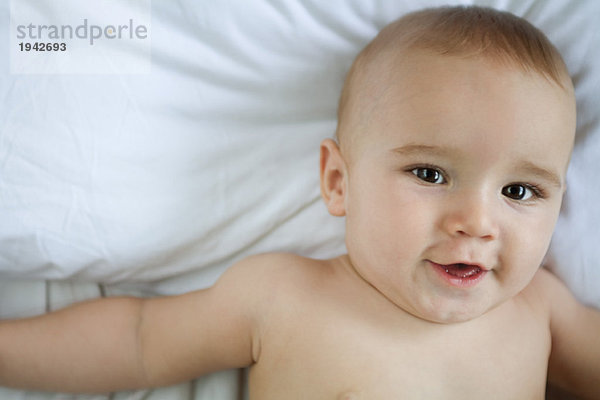 Baby auf dem Rücken liegend  mit Blick auf Kamera  Kopf und Schultern