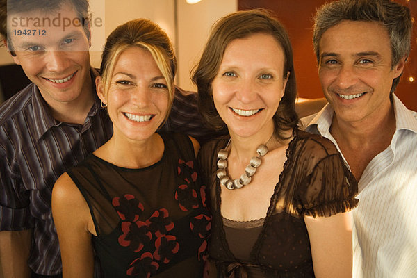 Vier erwachsene Freunde lächeln vor der Kamera  Gruppenportrait