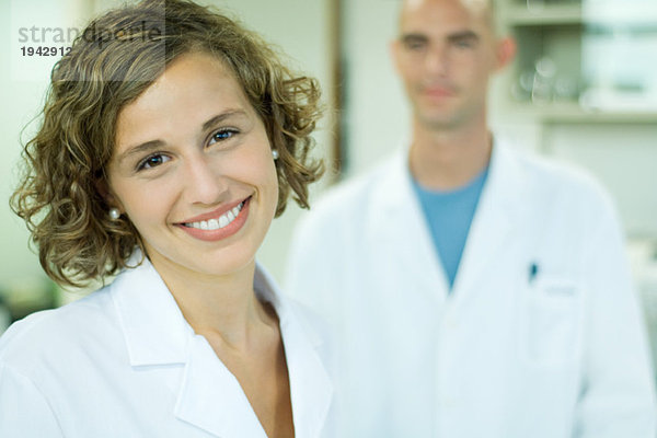 Ärztin lächelnd  Kollegin im Hintergrund  Porträt
