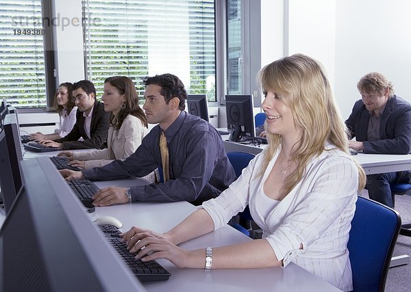 Seitenansicht der jungen Männer und jungen Frauen lernen Computer im Klassenzimmer