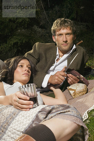 Young couple lying in meadow  having picnic