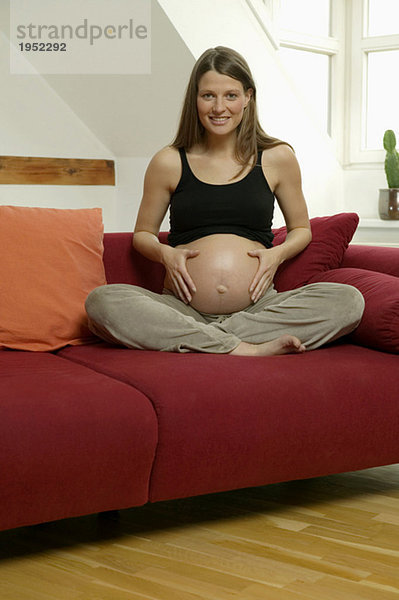 Schwangere Frau mit Händen auf dem Bauch