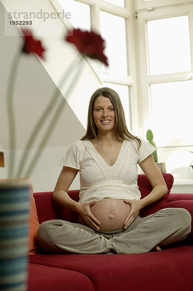 Schwangere Frau mit Händen auf dem Bauch