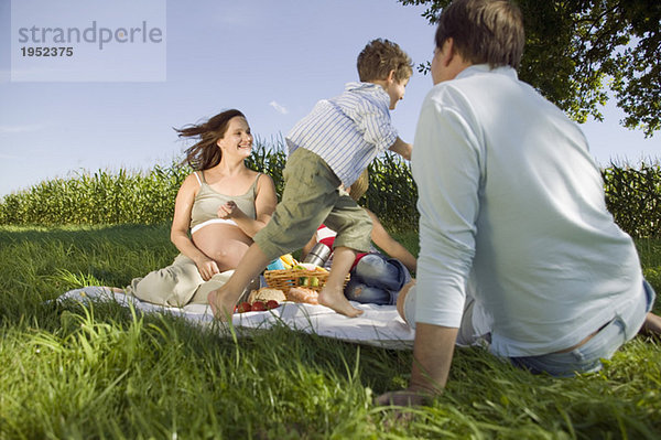 Eltern mit zwei Kindern (6-9) beim Picknick
