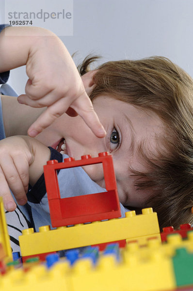 Junge spielt mit LEGO Steinen
