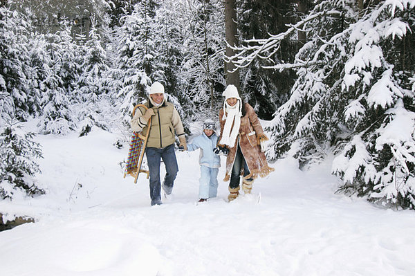 Österreich  Salzburger Land  Junge (6-7) mit Eltern im Schnee unterwegs