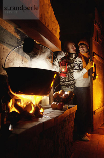 Paar in Almhütte am Kamin  Mann mit Lampe