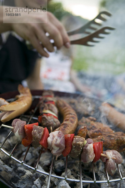 Fleisch- und Wurstwaren auf dem Grill im Hintergrund