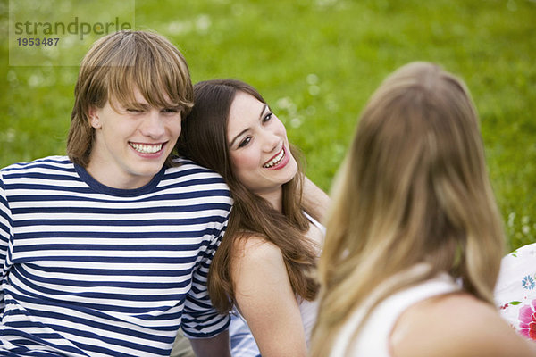 Teenager auf der Wiese sitzend