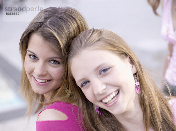 Zwei Teenager-Mädchen (16-17) lächelnd