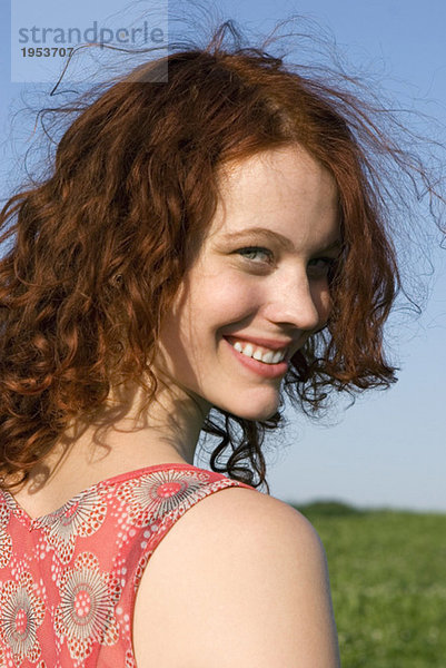 Junge Frau auf der Wiese stehend  lächelnd  Nahaufnahme  Porträt