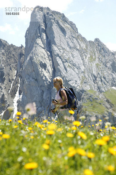 Frau beim Wandern in den österreichischen Alpen  Seitenansicht