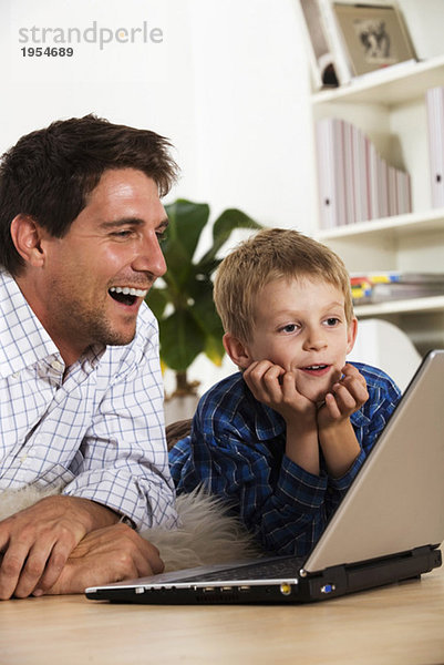 Vater und Sohn (6-7) mit Laptop