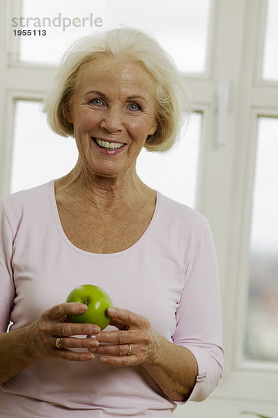 Seniorin mit Apfel  lächelnd  Nahaufnahme  Portrait